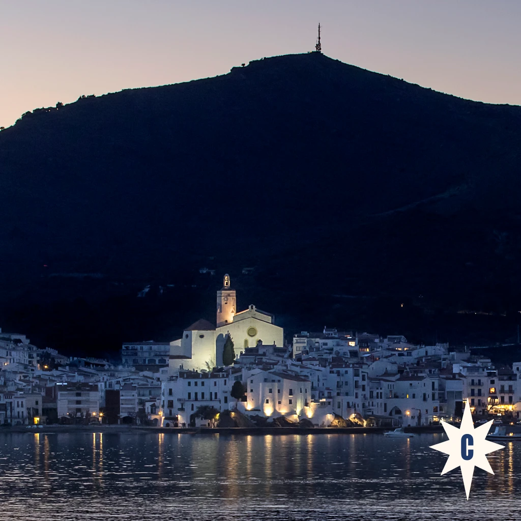 Vista nocturna de Cadaqués amb l’església de Santa Maria il·luminada davant del mar